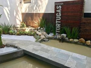 a small pond in the middle of a garden at Pousada Tortugas in Guarujá