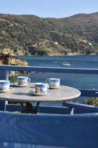 a table with cups and saucers on a balcony overlooking the water at LikoremaView in Marmari