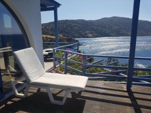 a white chair sitting on a porch overlooking the water at LikoremaView in Marmari