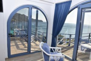 a room with a balcony with a view of the ocean at LikoremaView in Marmari +34 photos