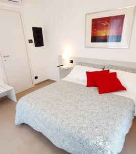 - une chambre avec un lit et un oreiller rouge dans l'établissement Affittacamere La Fonte, à Levanto