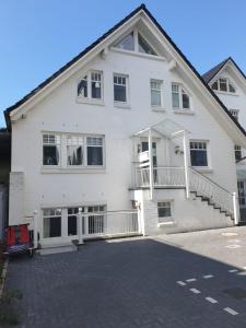 Cette maison blanche dispose d'un balcon et d'une allée. dans l'établissement Strandallee 150a, à Timmendorfer Strand