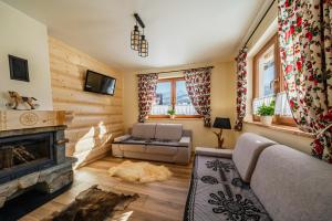 a living room with a couch and a fireplace at Noclegi domek in Kościelisko