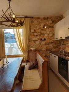 a kitchen with a counter and a table and a window at Appartamento in Madonna di Campiglio