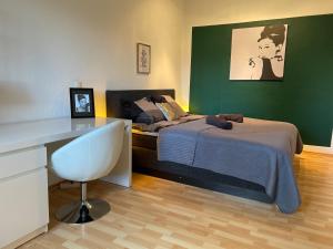 Schlafzimmer mit einem Bett, einem Schreibtisch und einem Stuhl in der Unterkunft Sky Night Suite in Düren - Eifel