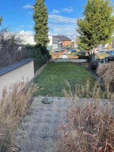 einen Garten mit einem Rasengarten mit Bäumen und einem Zaun in der Unterkunft Sky Night Suite in Düren - Eifel