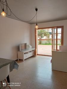een woonkamer met een tv op een kast en een glazen schuifdeur bij Apartament amb dues grans terrasses de 50 m2 i 16 m2 a 300 m de la platja in Sant Antoni de Calonge