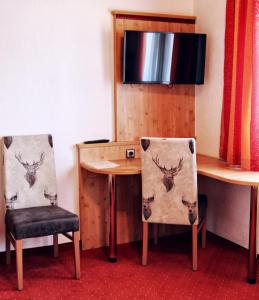 a room with a table and two chairs and a table with a deer head on at Hotel Paintner in Germering
