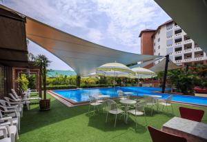 une terrasse avec des tables et des chaises ainsi qu'une piscine dans l'établissement Kwanruen Resort, à Nakhon Ratchasima
