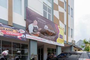 un bâtiment avec un panneau indiquant une grande ouverture dans l'établissement RedDoorz Syariah Plus @ BSD City, à Cilalung