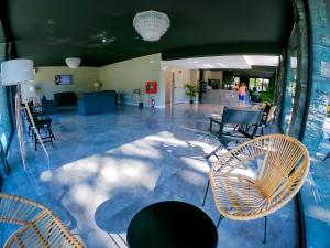 a lobby with chairs and tables in a building at Hotel Costa Verde in Milano Marittima