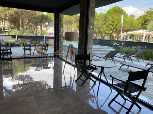 una habitación con sillas y mesas y una piscina en Hotel Costa Verde en Milano Marittima