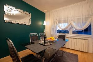 a dining room with a table and a green wall at Apartman Vesna in Bjelovar