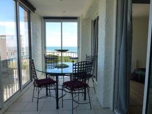une table et des chaises sur un balcon avec vue sur l'océan dans l'établissement Le Belvédère - T2 en front de mer, à Argelès-sur-Mer