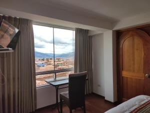 a room with a table and a window with a view at Casa del Escultor in Cusco
