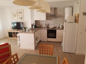 eine Küche mit einem weißen Kühlschrank und einem Tisch in der Unterkunft Cuesta del Tajillo in Torremolinos