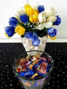 a vase with flowers and chips in a bowl at Sunny Apartments Gorlice in Gorlice