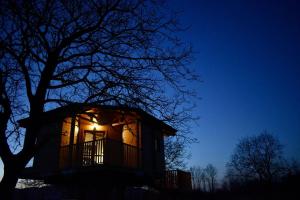 eine Hütte, die nachts mit einem Baum leuchtet in der Unterkunft Guarda Che Luna in Sasso di Castalda