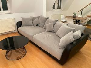 Charming Central Apartments في بادن بادن: أريكة سوداء في غرفة معيشة مع طاولة