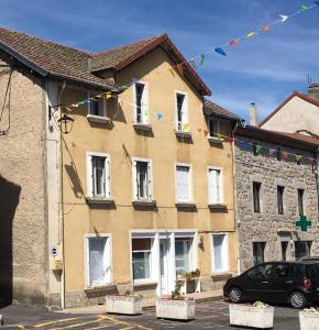 un edificio con un coche aparcado delante de él en La Maison de Soso, en Chambon-le-Château