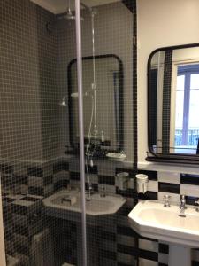 a bathroom with a sink and a mirror at Hotel Le Petit Chomel in Paris