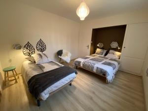 a bedroom with two beds and a table and a chair at GITE LAVANDE avec piscine privée CLASSÉ 4 Étoiles in Lagorce +38 photos