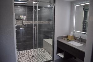 a bathroom with a glass shower with a sink at Budget Inn in La Puente