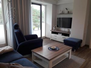 a living room with a couch and a tv at FeWo Meerblick Prora in Binz