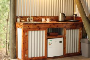 a kitchen with a counter and a sink and a refrigerator at Heritage Glamping, Woodlands tent in Wilderness