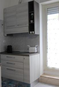a kitchen with white cabinets and a window at Smile - appartamento con giardino in Cagliari +5 photos