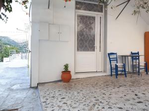 a porch with a door and a table and chairs at Despina garden view in Agia Galini