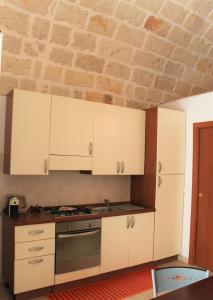 波利尼亞諾阿馬雷的住宿－Dimora Nonna Sisina，厨房配有白色橱柜和炉灶。