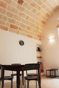 tavolo e sedie in una stanza con muro di mattoni di Dimora Nonna Sisina a Polignano a Mare