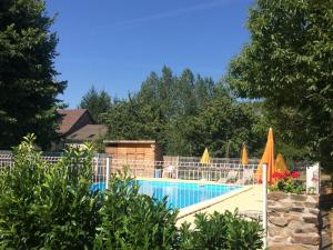 a swimming pool with a fence around it at Liabaquet Gîtes in Sarlande