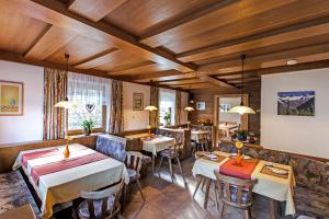 ein Restaurant mit Tischen und Stühlen in einem Zimmer in der Unterkunft Pension Mühlhof in Neukirchen am Großvenediger