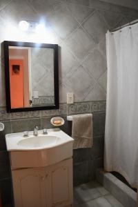 a bathroom with a sink and a mirror and a shower at Casa Bordó, B & B in Tandil