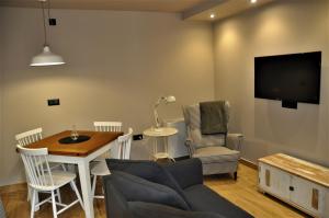 a living room with a table and chairs and a tv at Apartamentos Las Agüeras in Linares
