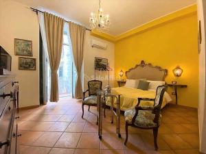 Un dormitorio con una cama y una mesa y sillas. en B&B Donna Anna, en Nápoles