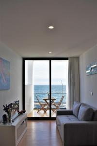 uma sala de estar com um sofá e vista para o oceano em Sky Blue Apartment em Ponta Delgada