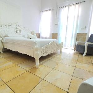 a white bed sitting in a room with windows at Lake Mansion in Tiberias