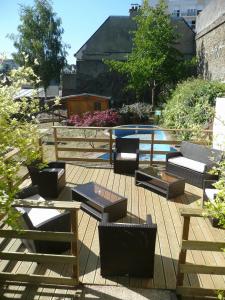 une terrasse avec des chaises et des tables, ainsi qu'une piscine. dans l'établissement Hotel De Clisson Saint Brieuc, à Saint-Brieuc