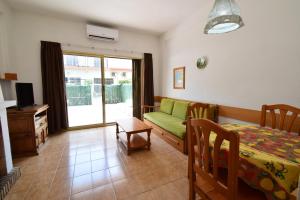 a living room with a green couch and a table at Rinconada Real - Fincas Arena in Benidorm