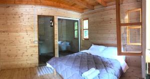 a bedroom with a bed in a wooden cabin at Blini-Park Guesthouse in Mollʼ e Shoshit