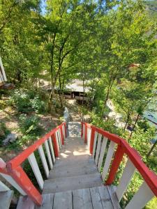 a wooden bridge with a red and white fence at Blini-Park Guesthouse in Mollʼ e Shoshit