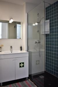 uma casa de banho com um lavatório e um chuveiro em Sky Blue Apartment em Ponta Delgada
