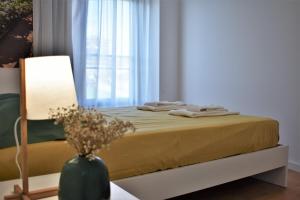 um quarto com uma cama com um candeeiro e uma janela em Sky Blue Apartment em Ponta Delgada