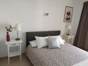 een slaapkamer met een bed met 2 nachtkastjes en 2 lampen bij Vivienda Vacacional Helios - Penthouse Deluxe in Tazacorte