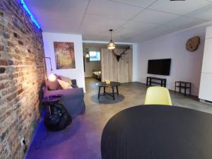 a living room with a brick wall and a table at La Librairie in Francorchamps