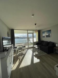 a living room with a couch and a view of the ocean at Strandbude 204 in Heiligenhafen