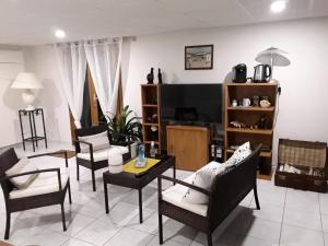 sala de estar con sillas, mesas y TV en Suite hauteurs de Vichy en Creuzier-le-Vieux